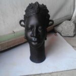 Intricate bronze sculpture by Rafiu Adam, representing African heritage, showcasing detailed craftsmanship and cultural significance.