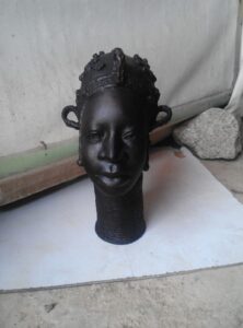 Intricate bronze sculpture by Rafiu Adam, representing African heritage, showcasing detailed craftsmanship and cultural significance.