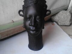 Intricate bronze sculpture by Rafiu Adam, representing African heritage, showcasing detailed craftsmanship and cultural significance.