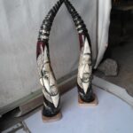 Intricate pair of cow horns featuring both painting and artistic carving, blending traditional techniques with contemporary flair, by Rafiu Adam.